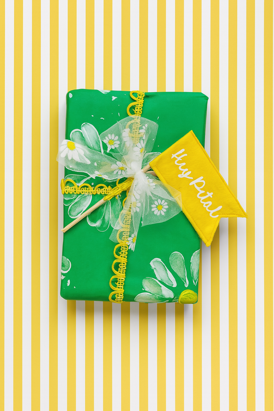 Handprinted daisy gift wrap with hey petal flag topper