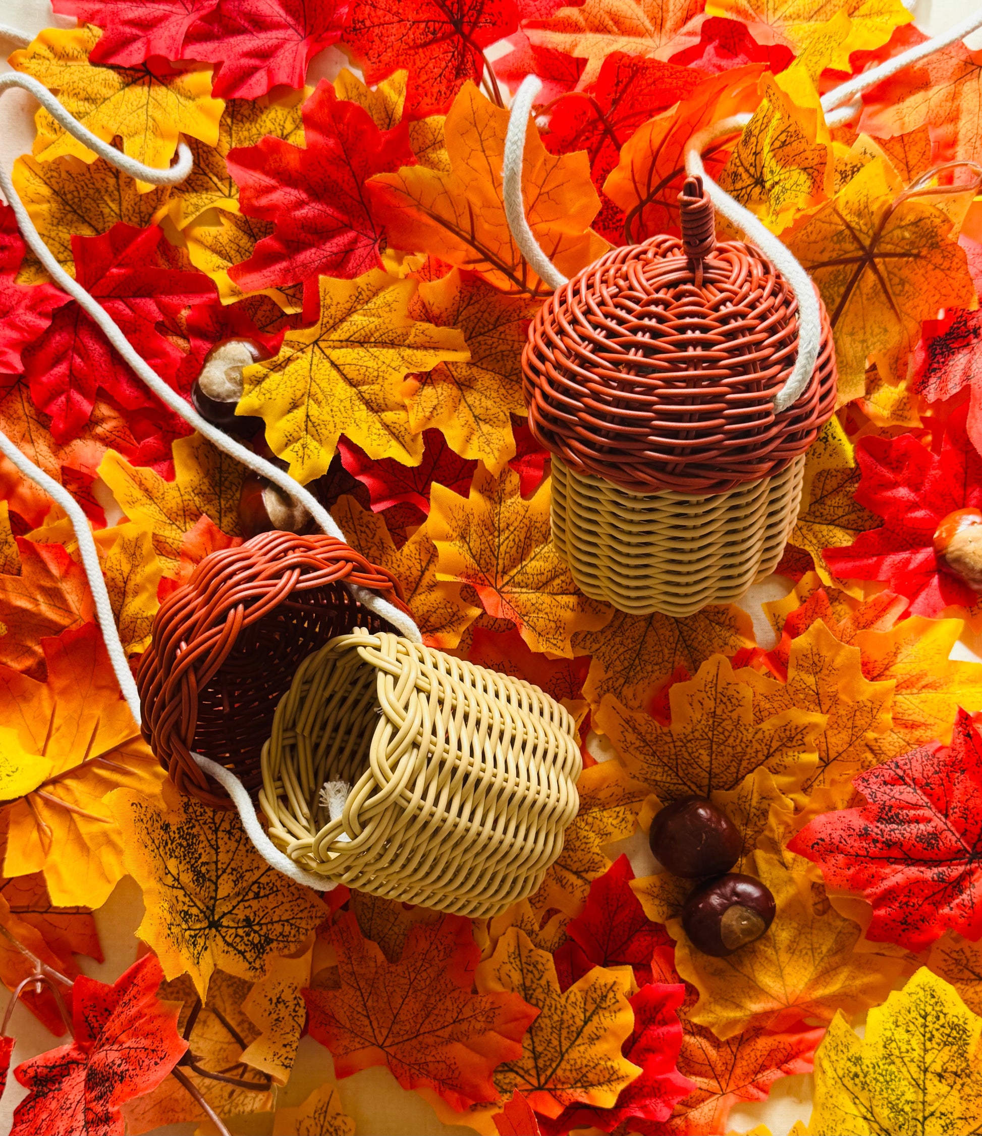 Wicker acorn-shaped bags on a bed of autumn leaves