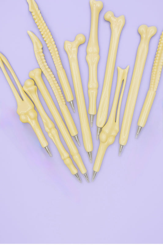 Set of bone-shaped pens on a purple background