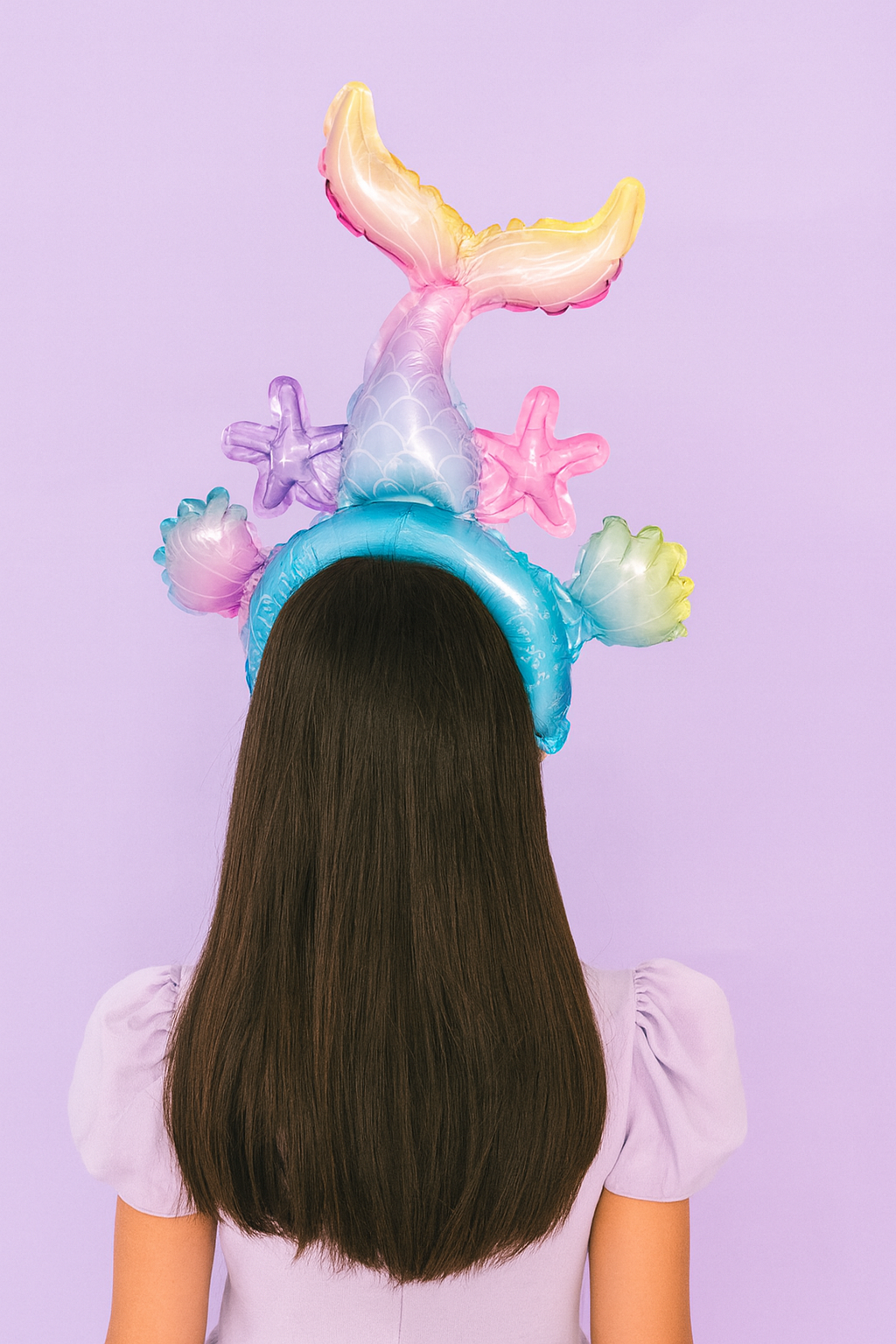 Person wearing a colorful mermaid tail headband against a purple background