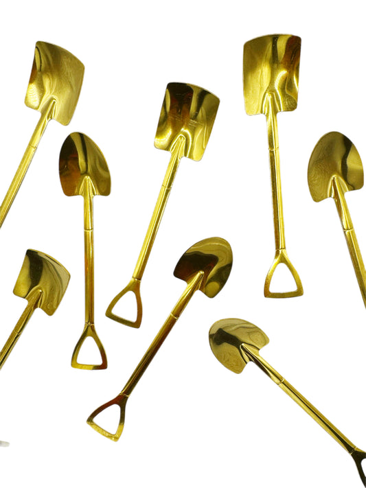 Gold-colored shovels arranged on a white background