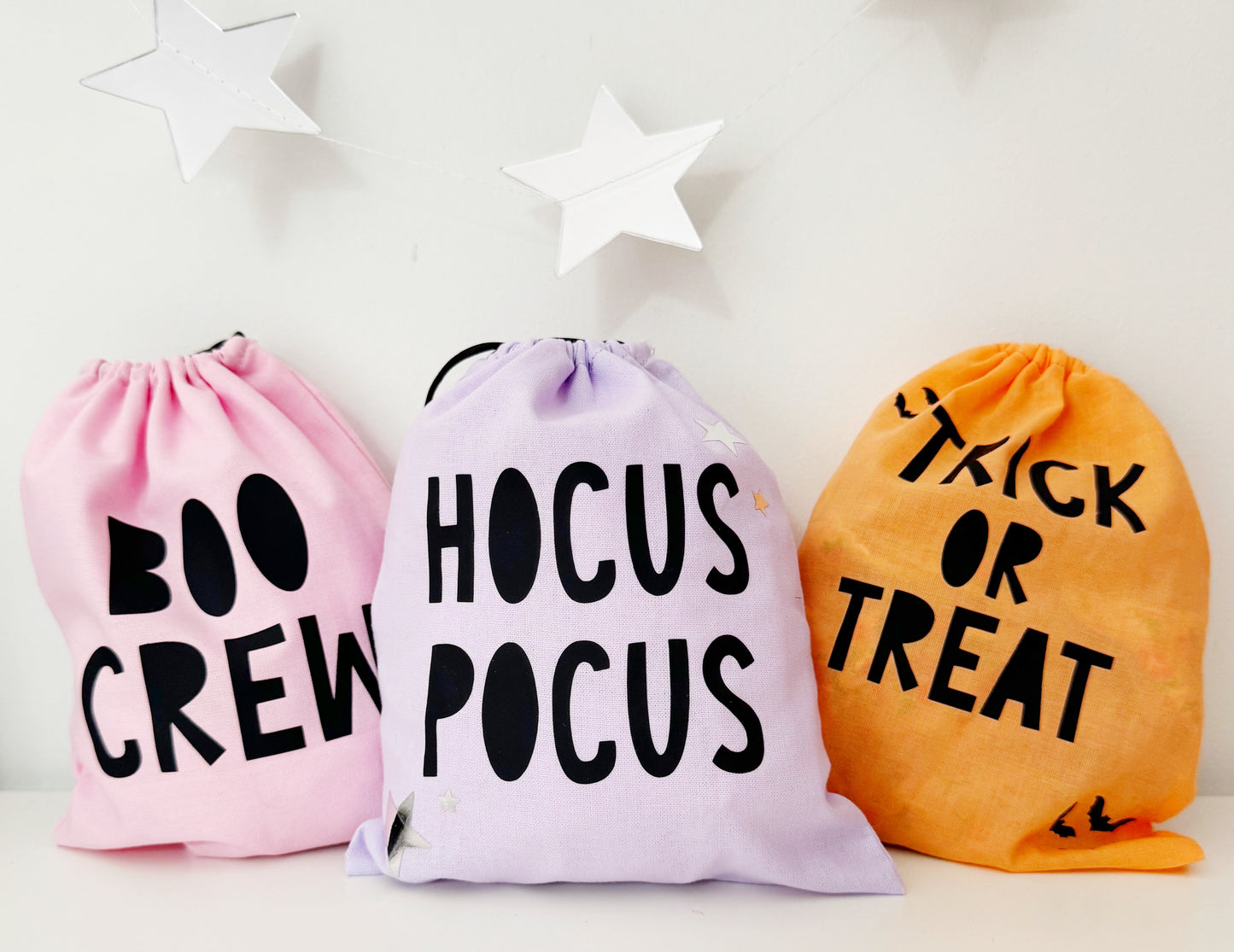 Three drawstring bags with Halloween-themed text on a white background
