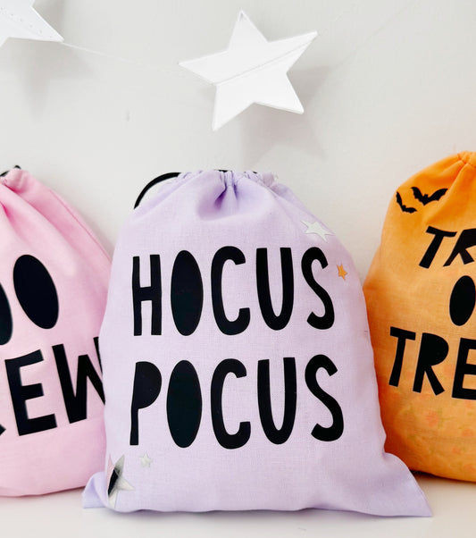 Three Halloween-themed drawstring bags with text on a white background