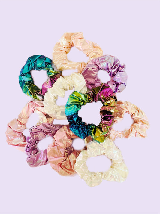 Set of colourful mermaid inspired scrunchies on a light purple background