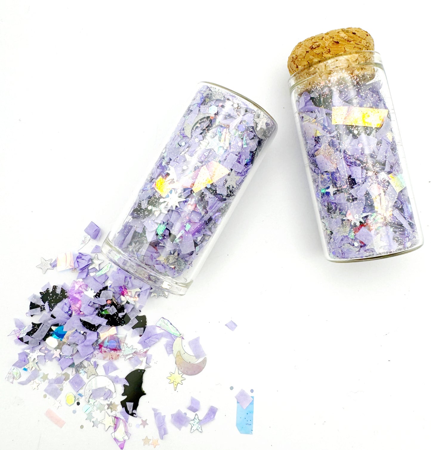 Two jars of Halloween-themed confetti with a cork lid on a white background