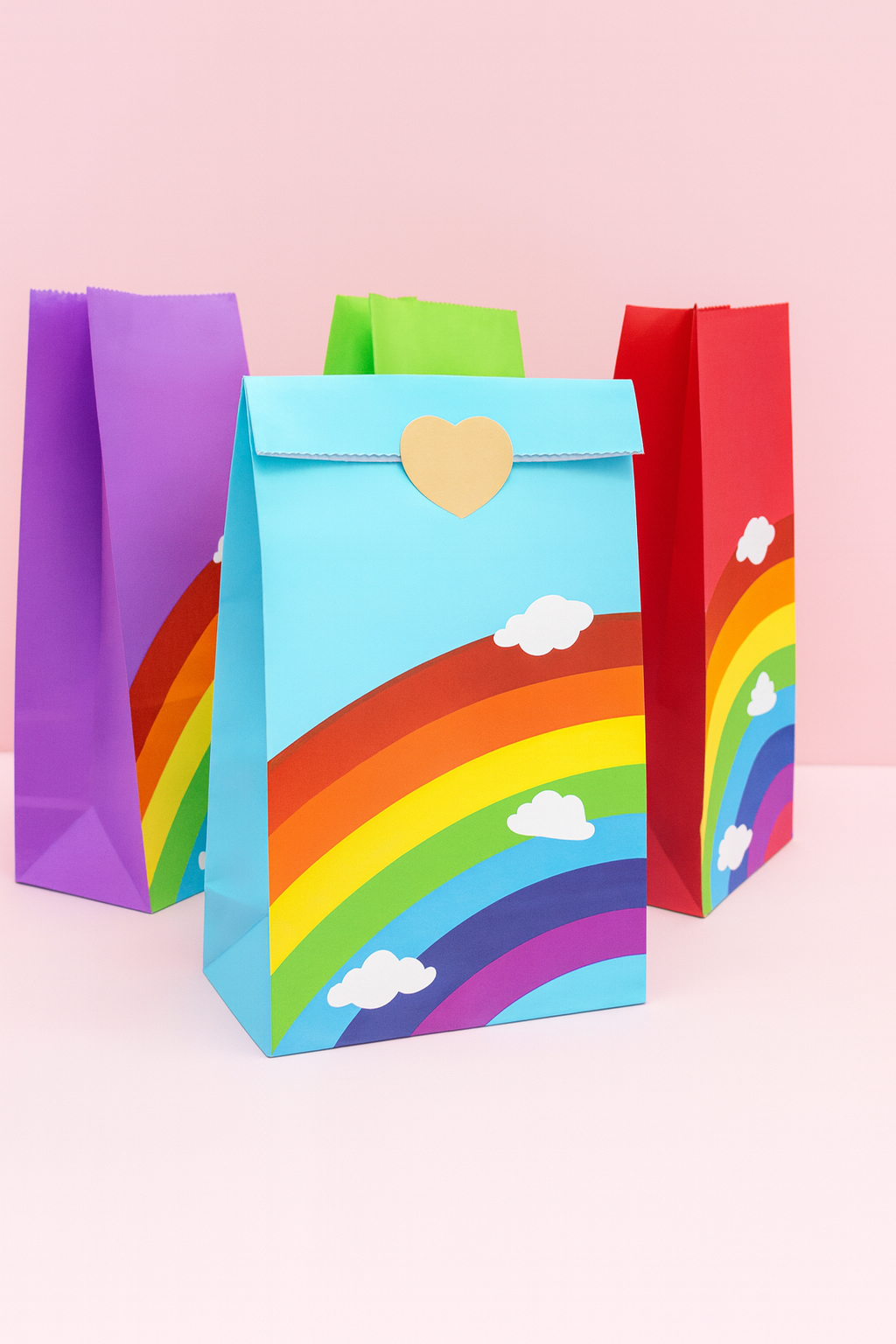 Colourful paper bags with rainbow designs on a pink background