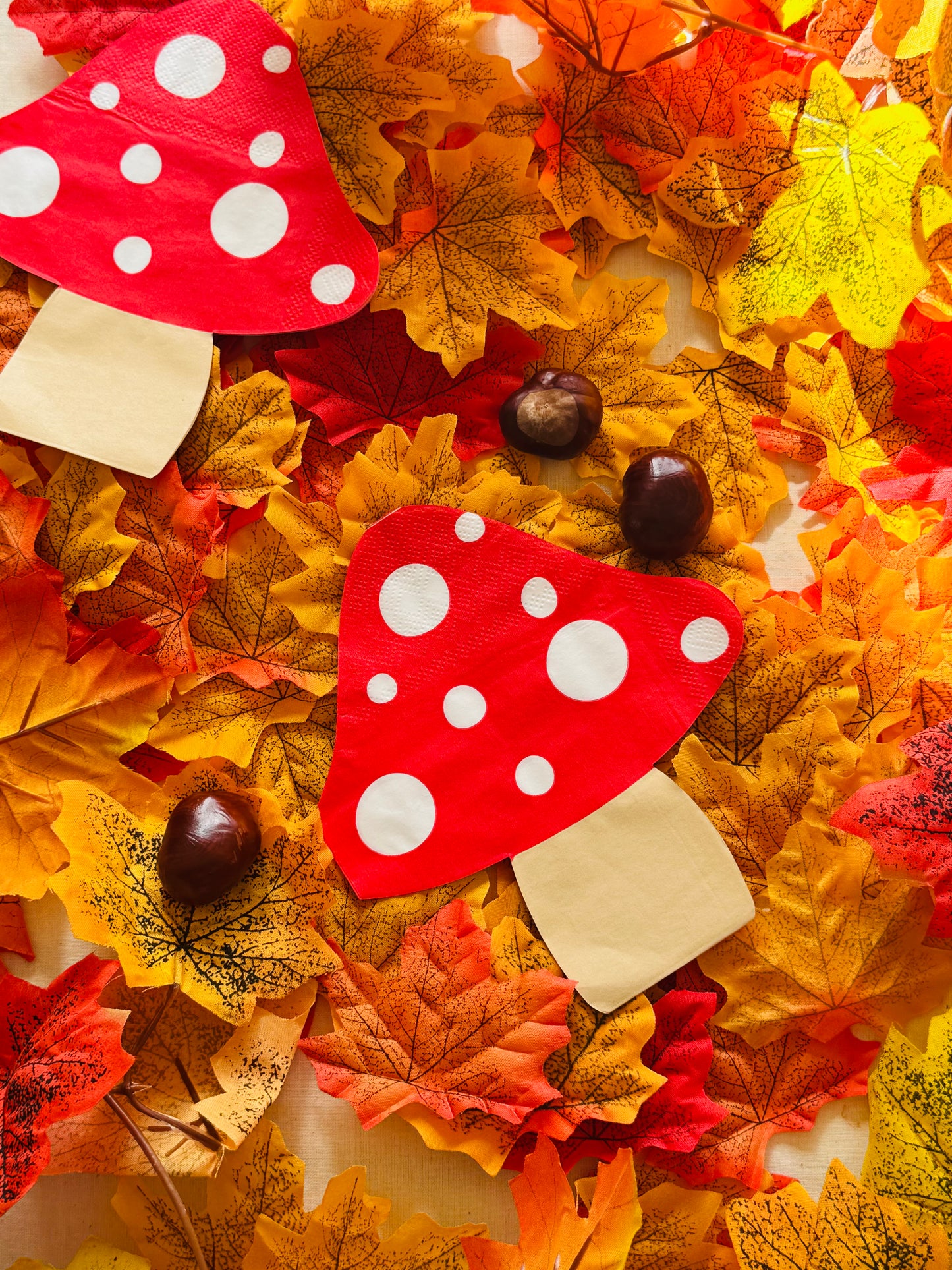 Decorative wreath with red and white polka dot toadstool napkins and autumn leaves.