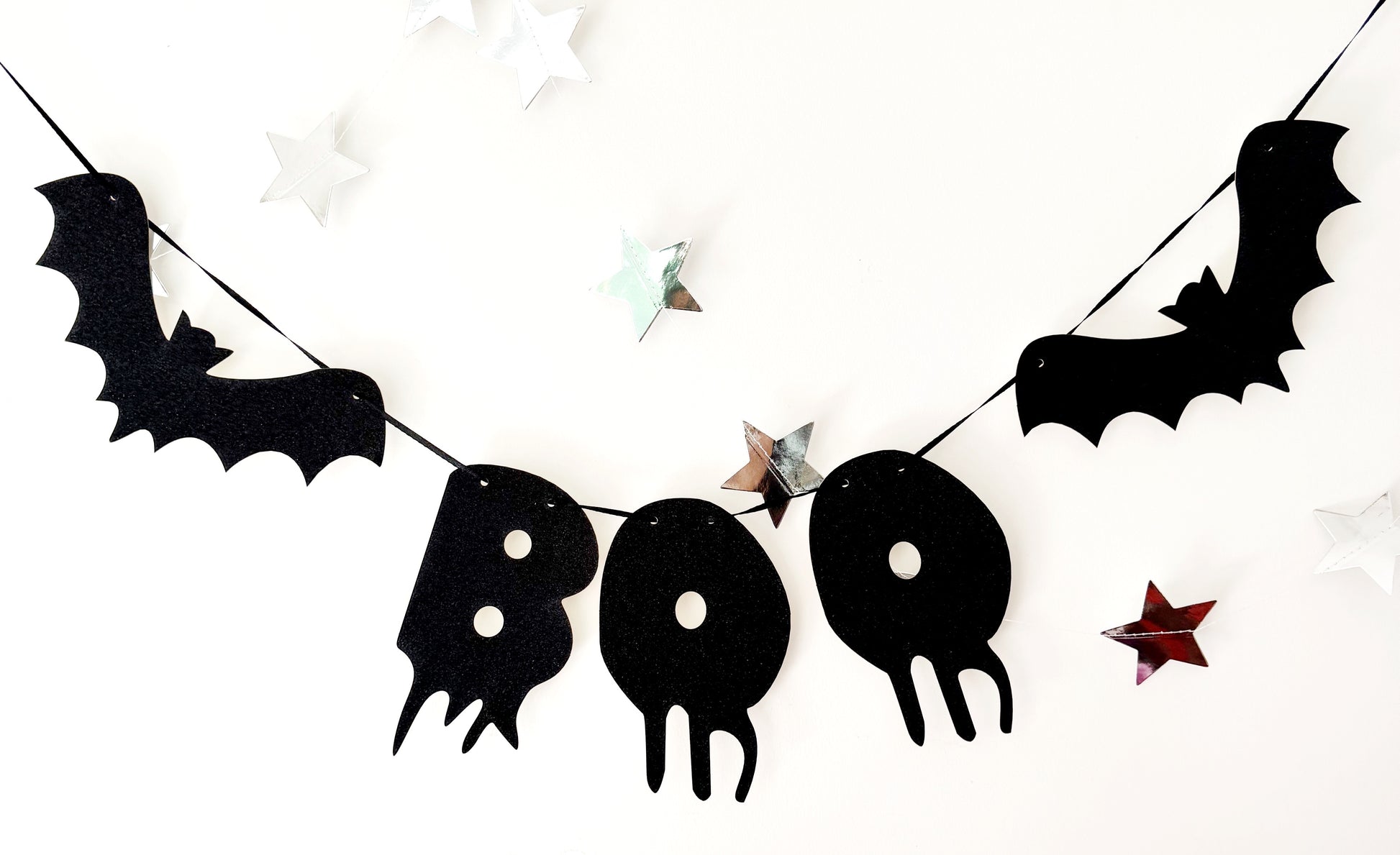 Halloween-themed banner with black bats and 'BOO' letters on a white background