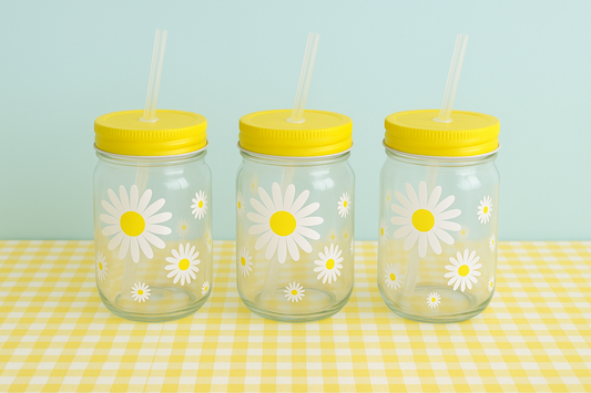 Daisy motif glass drinking jar with yellow screw on lid and plastic drinking straw