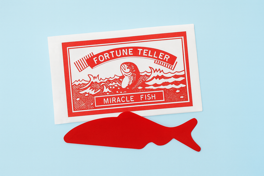 Red 'Fortune Teller Miracle Fish' toy on a light blue background