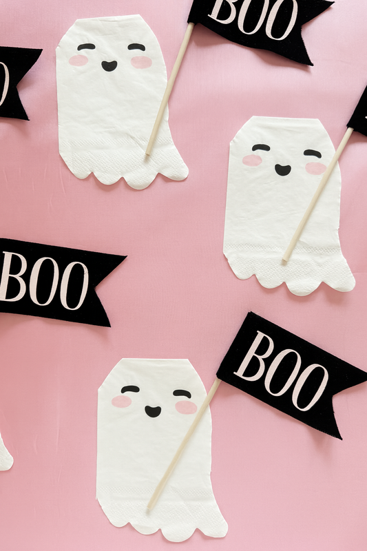 White ghost halloween napkins with black 'BOO' banners on a pink background