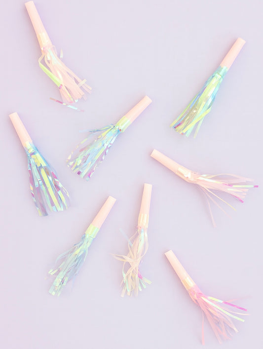 Iridescent party noisemakers on a light purple background
