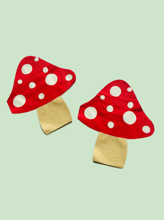 Two red mushroom-shaped hats with white spots on a light green background